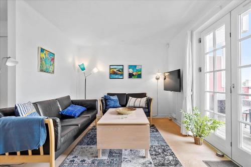 a living room with a black couch and a table at 11202-Nykobing-Sj-Havnevej-91-1-th in Nykøbing Sjælland