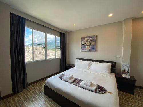 a bedroom with a large bed with a large window at ANANTAYA CHIANGMAI BOUTIQUE HOTEL in Chiang Mai