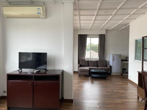 a living room with a couch and a flat screen tv at ANANTAYA CHIANGMAI BOUTIQUE HOTEL in Chiang Mai