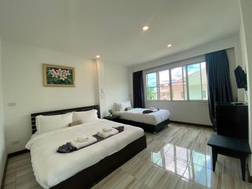 a hotel room with two beds and a television at ANANTAYA CHIANGMAI BOUTIQUE HOTEL in Chiang Mai