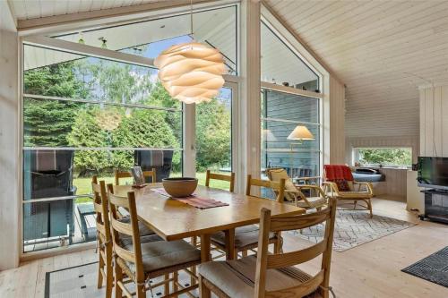 a dining room with a table and chairs and a large window at 11802-Nykobing-Sj-Gogetoften-10 in Nyrup