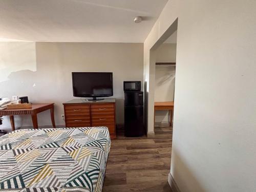 a room with a bed and a television and a table at Studio 6 Suites Mesquite, TX – Gross Rd. in Mesquite