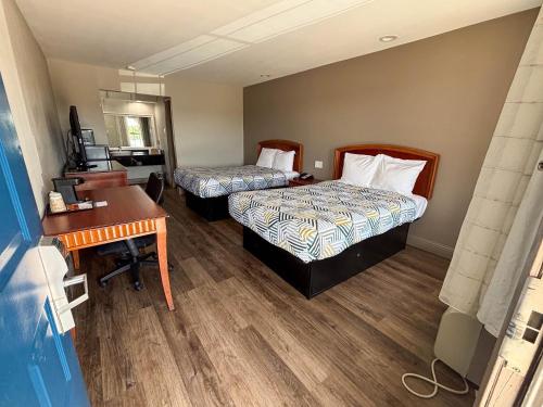 a hotel room with two beds and a desk at Studio 6 Suites Mesquite, TX – Gross Rd. in Mesquite