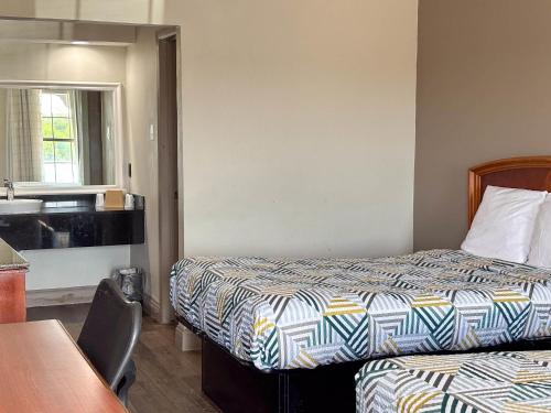 a hotel room with two beds and a table at Studio 6 Suites Mesquite, TX – Gross Rd. in Mesquite