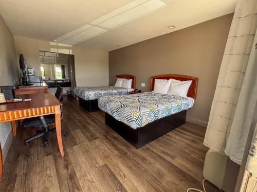 a hotel room with two beds and a desk at Studio 6 Suites Mesquite, TX – Gross Rd. in Mesquite