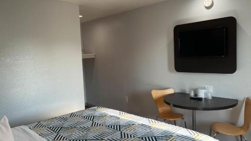 a bedroom with a bed and a table with a tv at Motel 6 Dallas, TX – St. Augustine / HWY 175 in Dallas