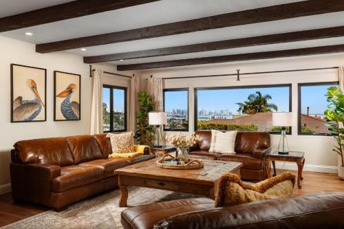 sala de estar con muebles de cuero y ventanas grandes. en Luxury Point Loma Retreat Pool Spa Views, en San Diego
