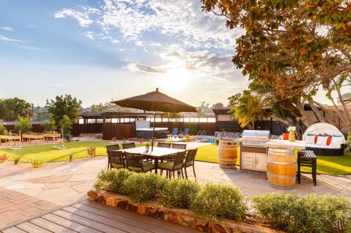 un patio al aire libre con mesa y sombrilla en Luxury Point Loma Retreat Pool Spa Views, en San Diego