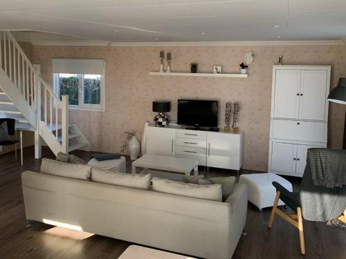 a living room with a couch and a tv at Holiday home on the recreational lake in Lathum