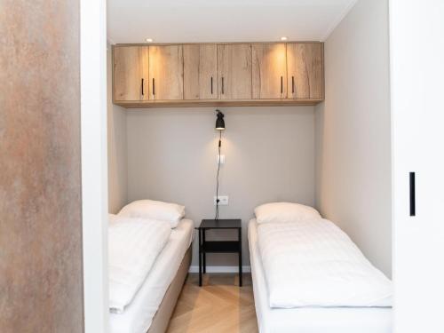 two beds in a small room with wooden cabinets at Holiday Home Bemelen near Nature Reserve in Bemelen