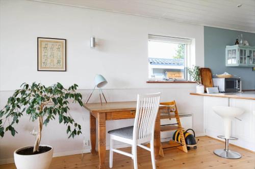 a kitchen with a table and a chair and a plant at 14242-Vig-Maglehojvej-6 in Vig