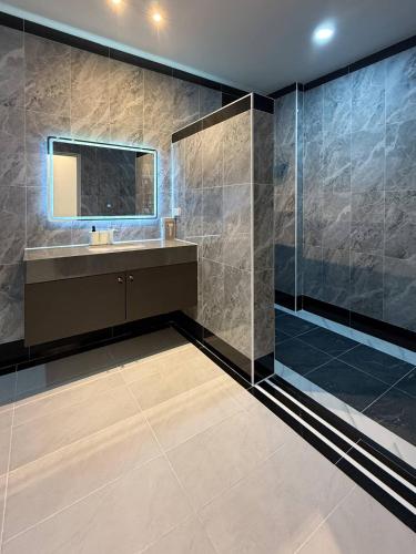 a bathroom with a shower and a sink and a mirror at FLEX Pool Villa in Pattaya