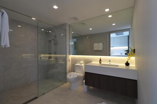 a bathroom with a toilet and a sink and a shower at Sunshine Prestige Resort and Spa in Cha Am