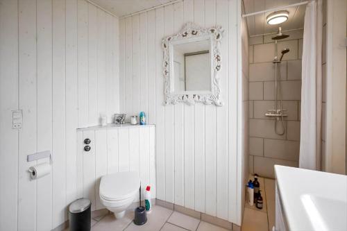 une salle de bain avec toilettes, lavabo et miroir dans l'établissement 12251-1-Sjaellands-Odde-Hyggebovej-3, à Tjørneholm