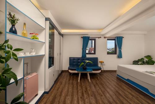 um quarto com uma cadeira azul e uma cama em Dana Sea Ngoc Bich em Da Nang