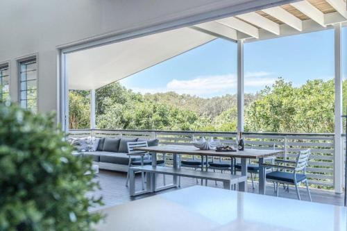 un patio con tavolo, sedie e un divano di Beachside House in Sebel Resort a Twin Waters