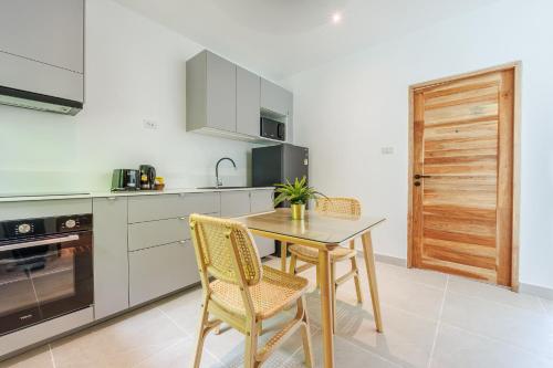 a kitchen with a table and chairs in a kitchen at Baan Saint-Tropez Seaview Villas Kata Beach in Kata Beach
