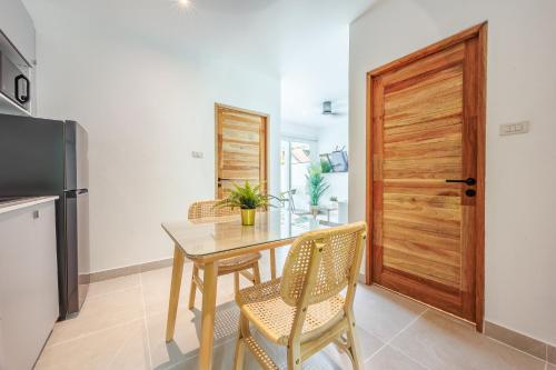 a dining room with a table and a wooden door at Baan Saint-Tropez Seaview Villas Kata Beach in Kata Beach