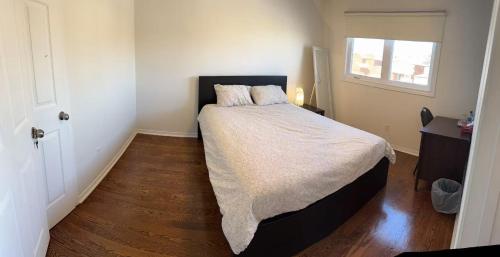 a bedroom with a large bed with a wooden floor at Bright private single bedroom V02 on second floor in Mississauga
