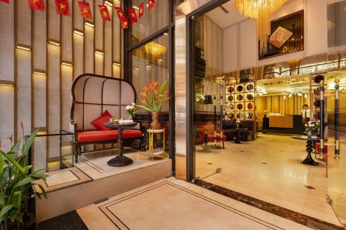 a lobby with a red chair in a building at Le Premier Hotel & Rooftop Bar in Hanoi