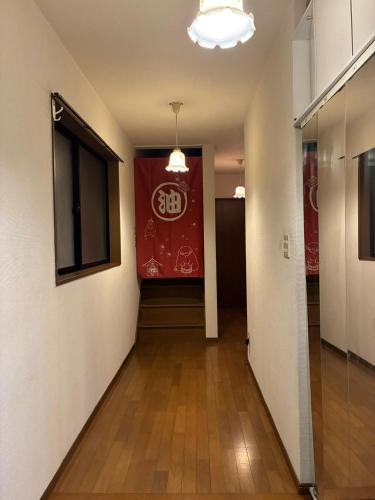 a hallway with a red sign on the wall at エアポートマジカ in Toyonaka