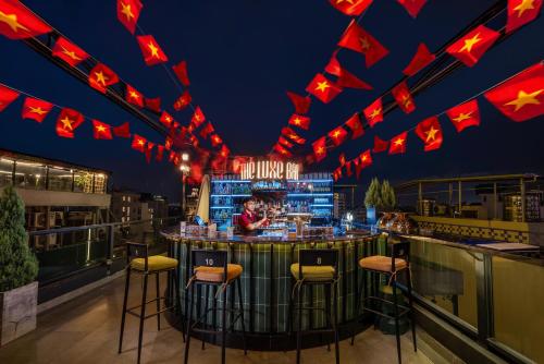 a bar at a nightclub with red lights and stools at Le Premier Hotel & Rooftop Bar in Hanoi