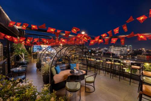 a rooftop bar with a view of the city at night at Le Premier Hotel & Rooftop Bar in Hanoi