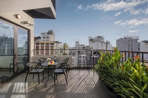 a balcony with a table and chairs on a balcony at Le Premier Hotel & Rooftop Bar in Hanoi