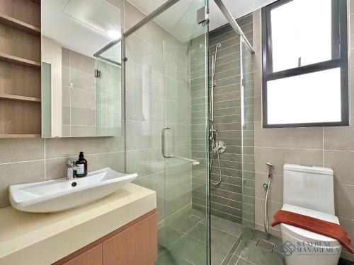 a bathroom with a sink and a glass shower at Macrolink Medini Legoland by Stayrene in Kangkar Pendas