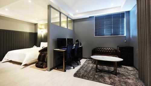 a bedroom with a bed and a desk and a mirror at 알마비즈니스호텔 in Jincheon