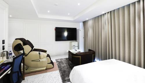 a hotel room with a bed and a television at 알마비즈니스호텔 in Jincheon