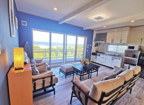 a living room with couches and a kitchen with a view at Qiao No,105 - Vacation STAY 75661v in Hokota
