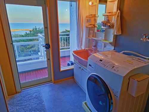 a washing machine in a bathroom with a view of the ocean at Qiao No,105 - Vacation STAY 75661v in Hokota