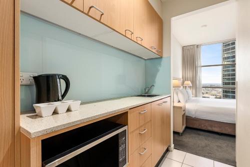 a kitchen with a sink and a bed in a room at Nolo Apartments Lonsdale St in Melbourne