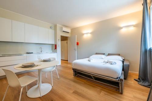 a bedroom with a bed and a table and chairs at Vaga's Nest - Modern Studio Apartment in Milan