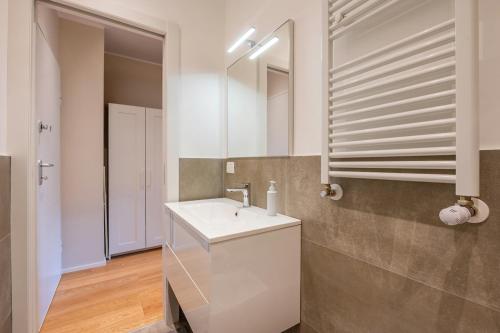 a bathroom with a white sink and a mirror at Vaga's Nest - Modern Studio Apartment in Milan
