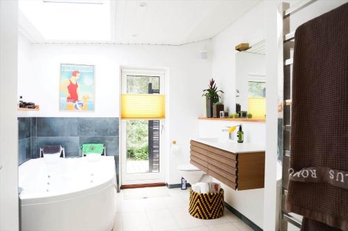 10013-1-Nykobing-Sj-Chr-Petersensvej-35 في Rørvig: حمام مع حوض استحمام أبيض ومغسلة