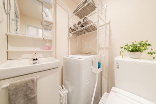 a bathroom with a sink and a washer and dryer at Intervia Horikiri in Tokyo