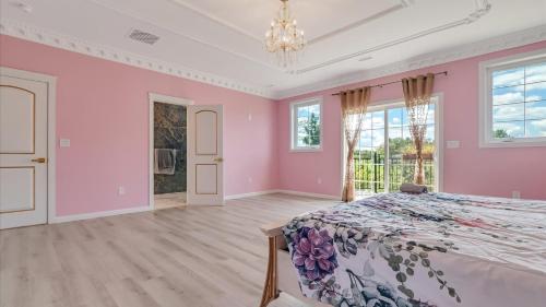 a pink bedroom with a bed and a chandelier at VIP Mansion Estate in Blakeslee