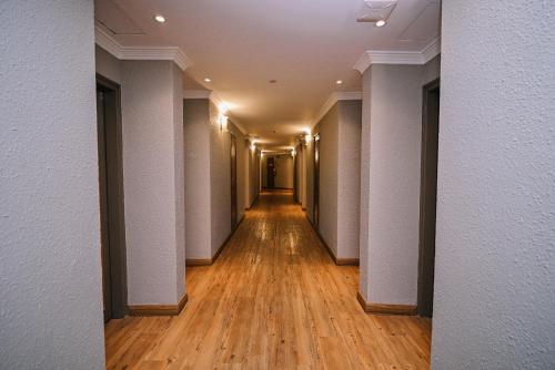 an empty corridor in a building with wood floors at Kingston Hotel 11 - PWTC, KL in Kuala Lumpur