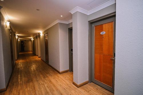an empty hallway with a wooden door in a building at Kingston Hotel 11 - PWTC, KL in Kuala Lumpur