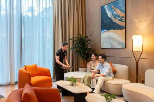 a group of people sitting in a living room at A La Carte Ha Long Bay Managed by TASECO in Ha Long