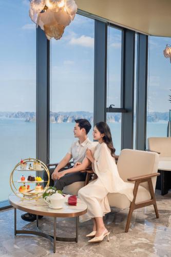 a man and woman sitting in a room with a table at A La Carte Ha Long Bay Managed by TASECO in Ha Long