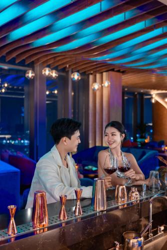 a man and a woman sitting at a bar at A La Carte Ha Long Bay Managed by TASECO in Ha Long