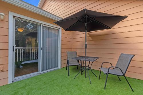 a table and chairs with an umbrella on a patio at Luxury 3BR Condo Near Disney with Pool in Kissimmee