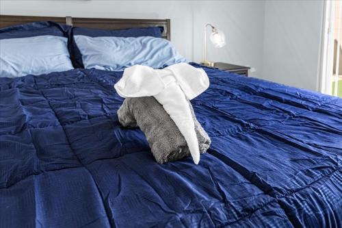 a stuffed elephant laying on top of a blue bed at Luxury 3BR Condo Near Disney with Pool in Kissimmee