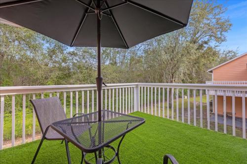 a patio with a chair and an umbrella at Luxury 3BR Condo Near Disney with Pool in Kissimmee