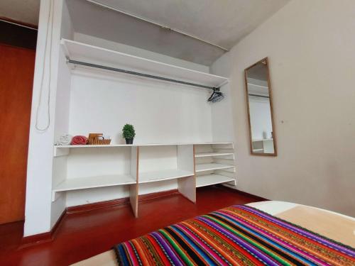 a bedroom with white shelves and a mirror at Sumaq Wasi Caminos Del Inca in Lima
