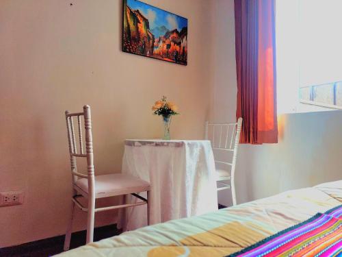 a room with a table and a vase with flowers on it at Sumaq Wasi Caminos Del Inca in Lima
