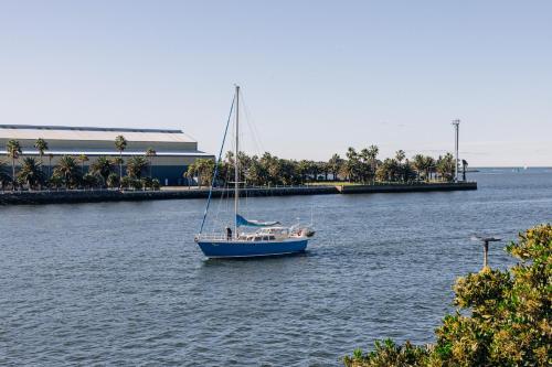 a sail boat in the water near a building at Rydges Newcastle in Newcastle